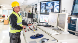 mężczyzna w odzieży roboczej wykonuje przy panelu czynności z zakresu optymalizacji gospodarki odpadami w firmie