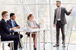 ekspert ds. ochrony środowiska stoi przy flipcharcie i prowadzi szkolenie z zakresu ochrony środowiska dla pracownik&oacute;w